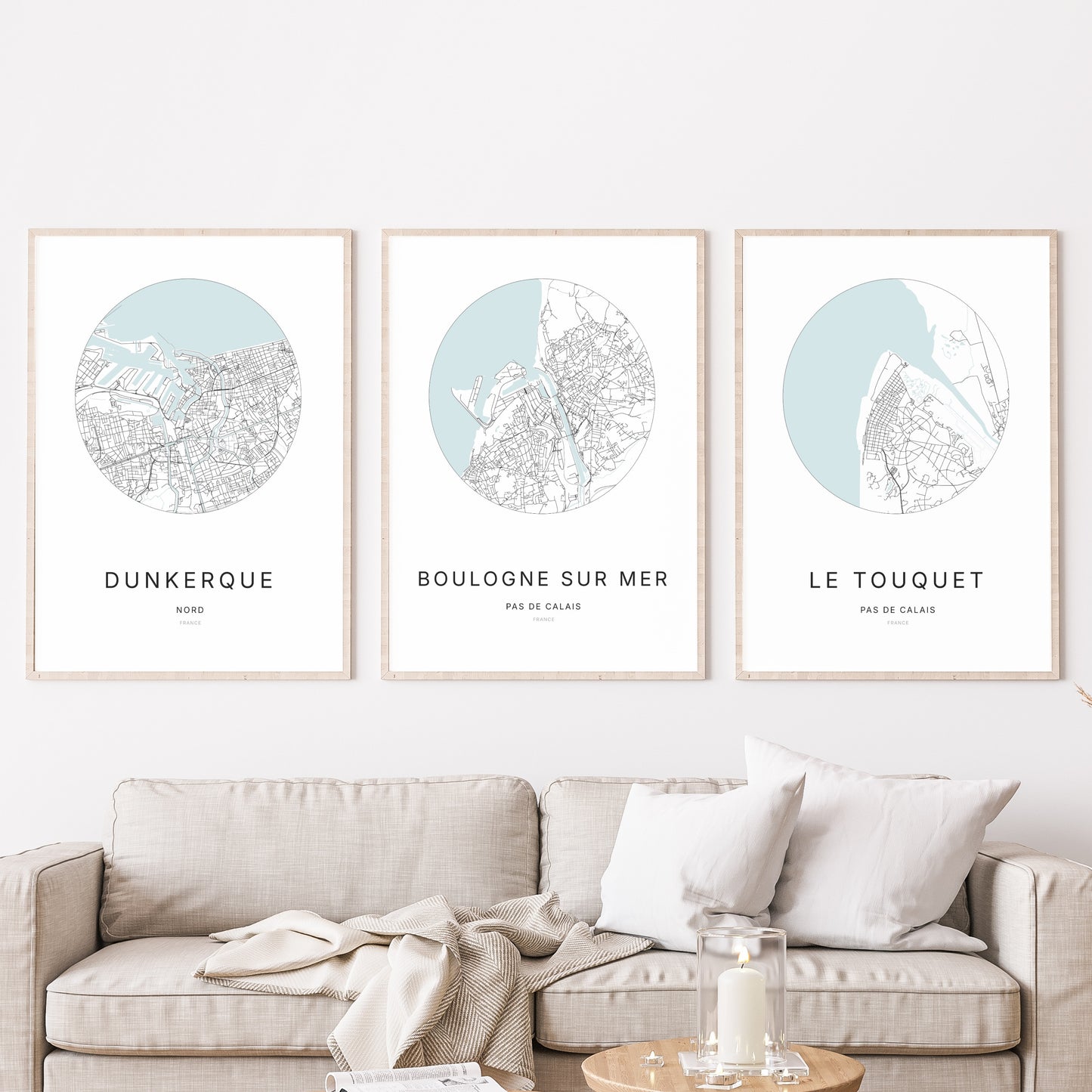 Composition murale de trois affiches minimalistes de villes (Boulogne-sur-Mer, Dunkerque, Le Touquet) encadrées au-dessus d’un canapé dans un salon moderne.