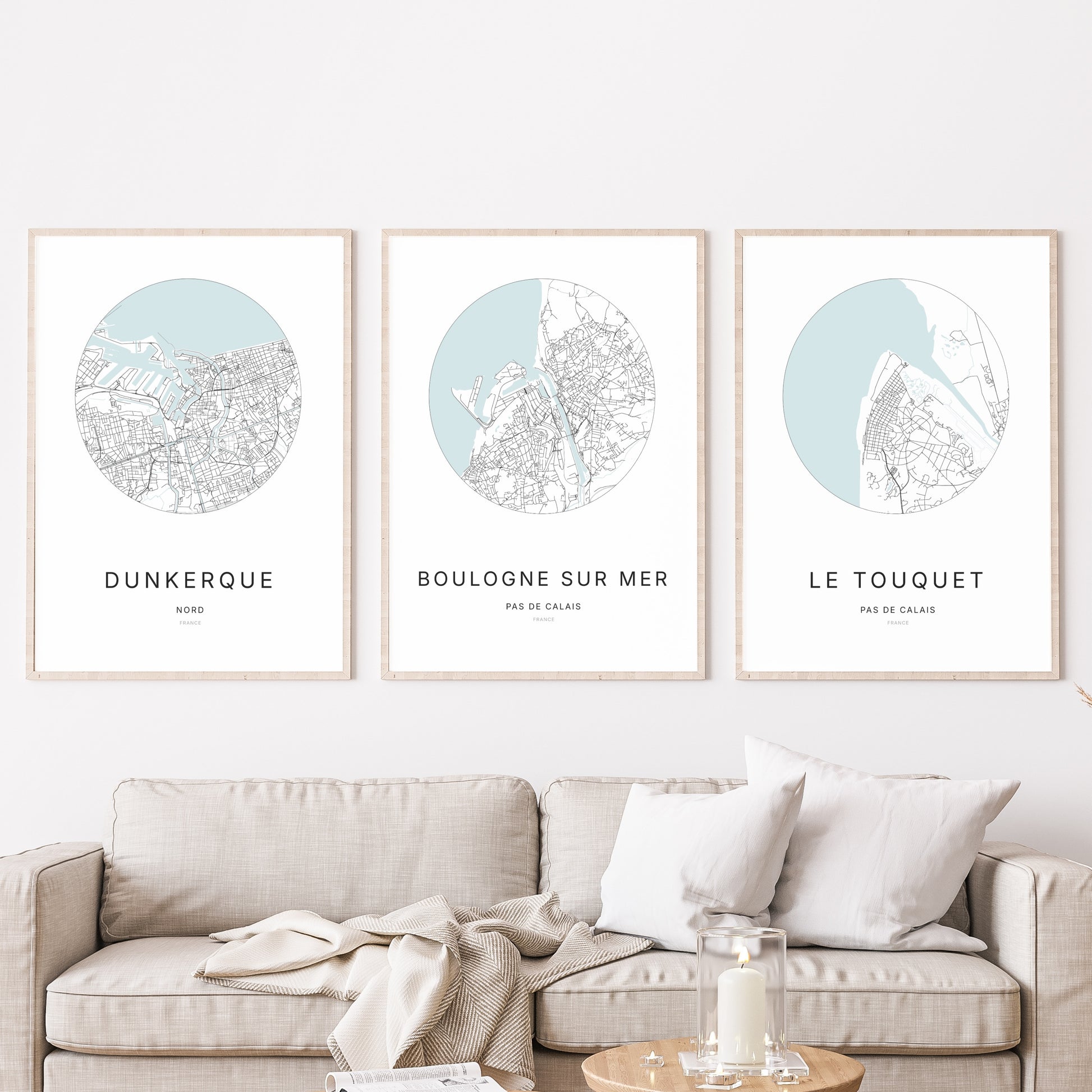 Composition murale de trois affiches minimalistes de villes (Boulogne-sur-Mer, Dunkerque, Le Touquet) encadrées au-dessus d’un canapé dans un salon moderne.