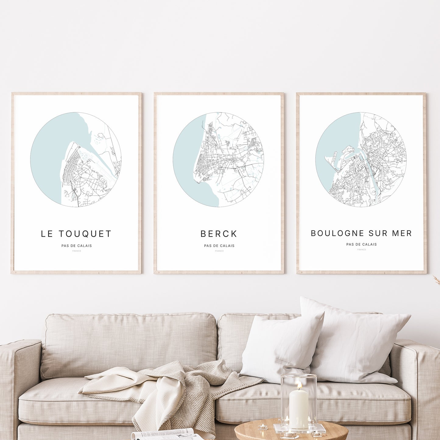 Composition murale de trois affiches minimalistes de villes (Berck, Le Touquet-Paris-Plage, Boulogne-sur-Mer) encadrées au-dessus d’un canapé dans un salon moderne.