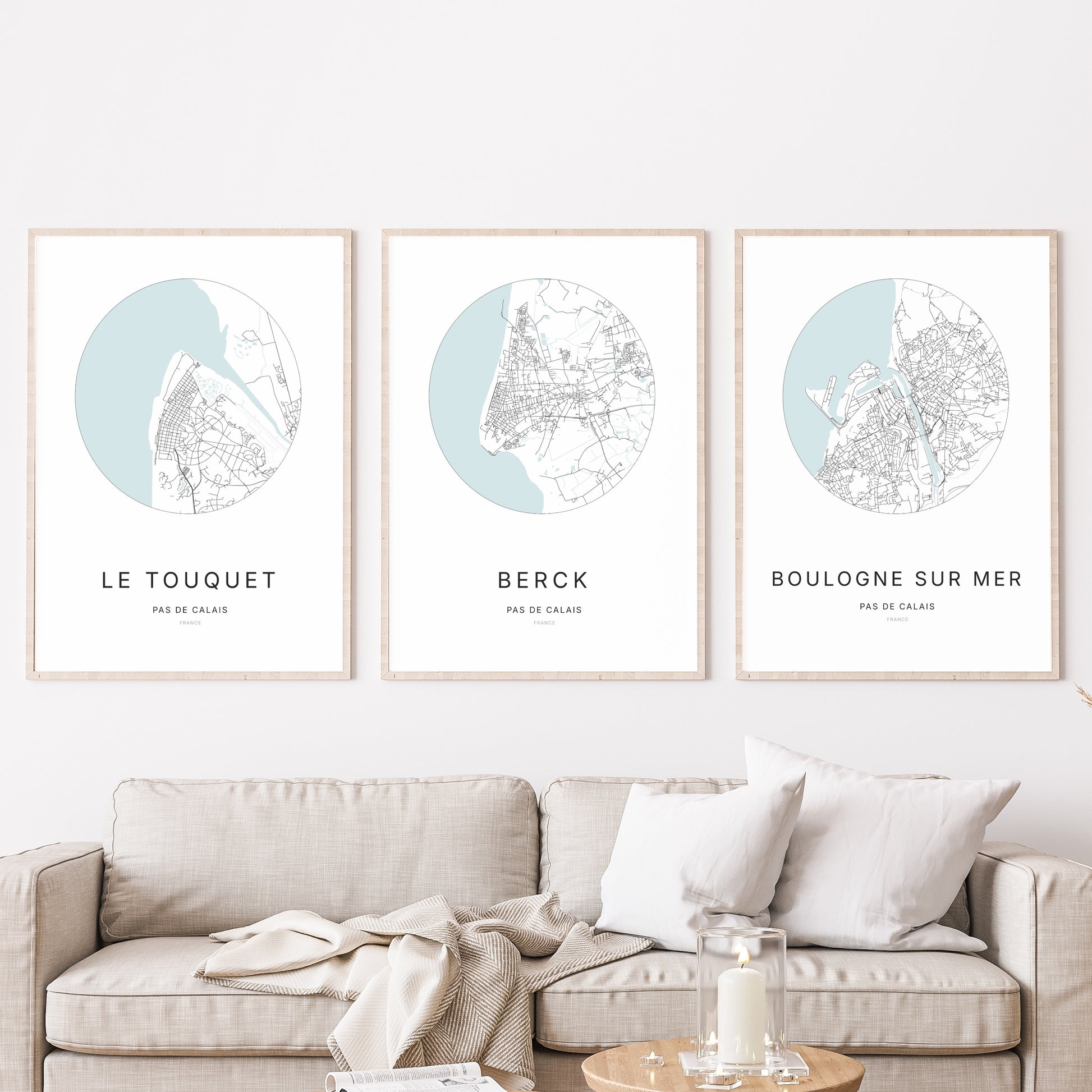 Composition murale de trois affiches minimalistes de villes (Berck, Le Touquet-Paris-Plage, Boulogne-sur-Mer) encadrées au-dessus d’un canapé dans un salon moderne.