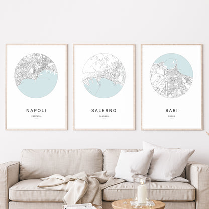 Composition murale de trois affiches minimalistes de villes (Salerno, Napoli, Bari) encadrées au-dessus d’un canapé dans un salon moderne.