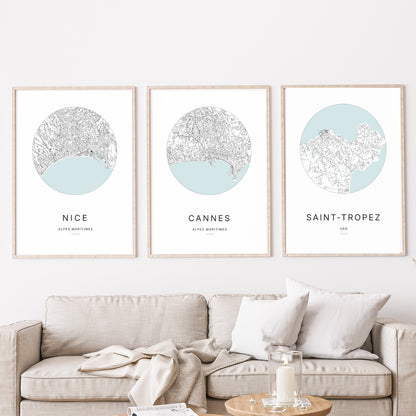 Composition murale de trois affiches minimalistes de villes (Cannes, Nice, Saint tropez) encadrées au-dessus d’un canapé dans un salon moderne