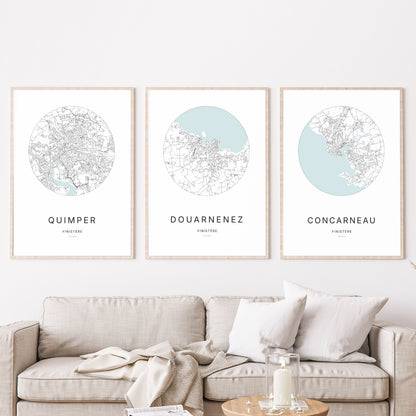Composition murale de trois affiches minimalistes de villes (Douarnenez, Quimper, Concarneau) encadrées au-dessus d’un canapé dans un salon moderne.