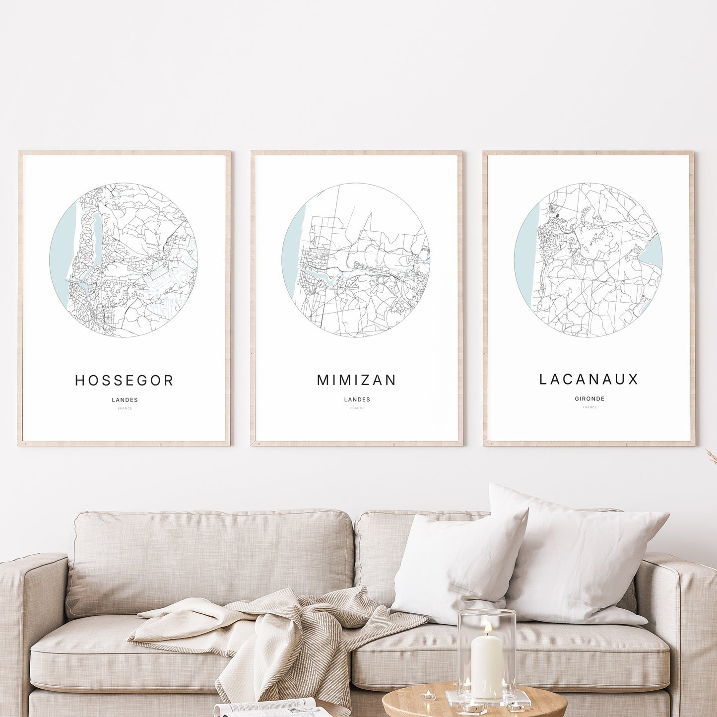 Composition murale de trois affiches minimalistes de villes (Mimizan, Hossegor, Lacanau) encadrées au-dessus d’un canapé dans un salon moderne.