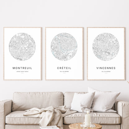 Composition murale de trois affiches minimalistes de villes (Créteil, Montreuil, Vincennes) encadrées au-dessus d’un canapé dans un salon moderne.