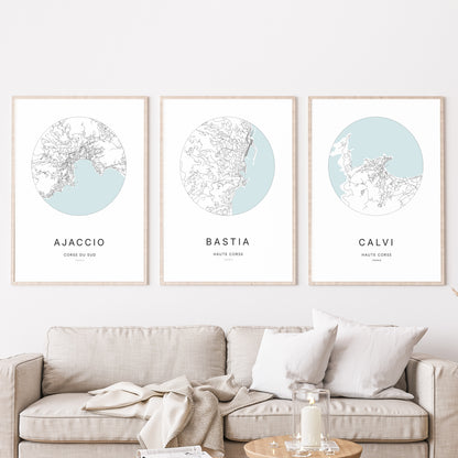 Composition murale de trois affiches minimalistes de villes (Bastia, Ajaccio, Calvi) encadrées au-dessus d’un canapé dans un salon moderne.