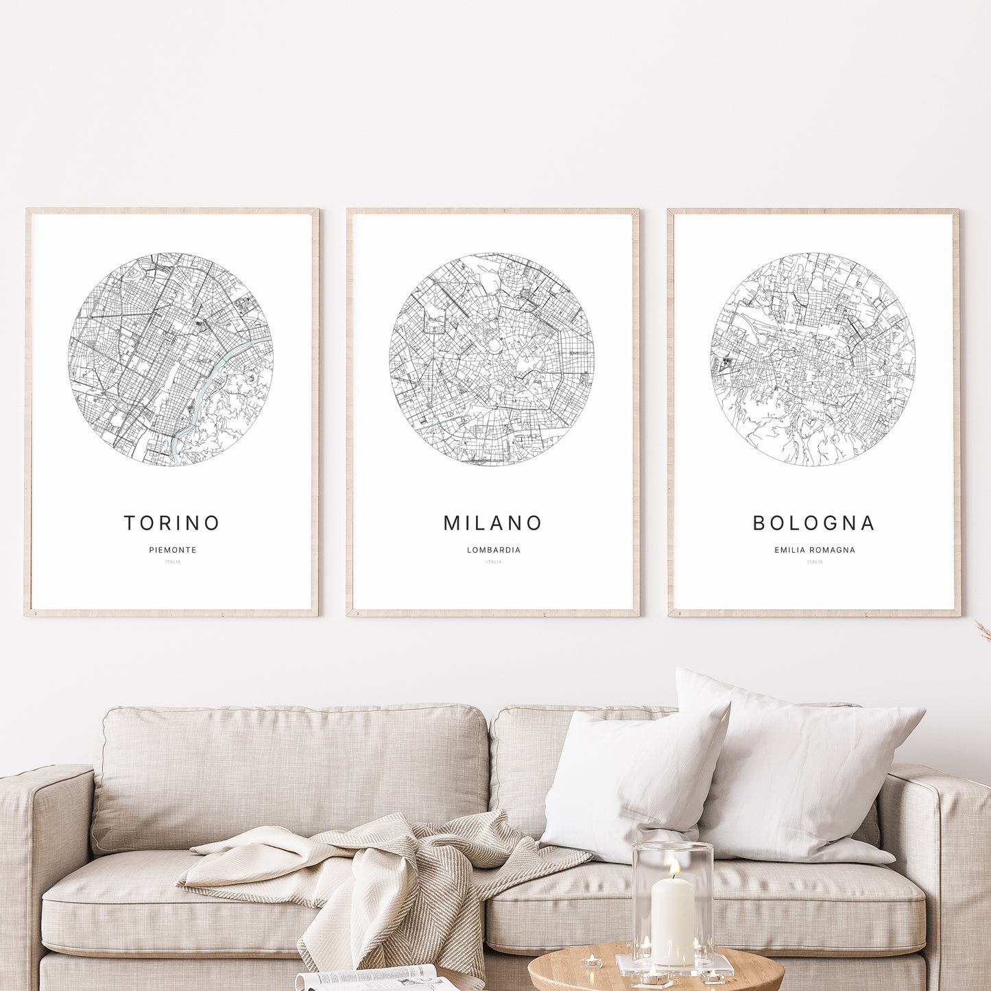 Composition murale de trois affiches minimalistes de villes (Milano, Torino, Bologna) encadrées au-dessus d’un canapé dans un salon moderne.