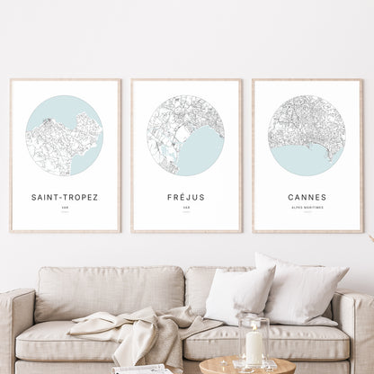 Composition murale de trois affiches minimalistes de villes (Fréjus, Saint-Tropez, Cannes) encadrées au-dessus d’un canapé dans un salon moderne.