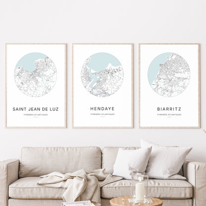 Composition murale de trois affiches minimalistes de villes (Hendaye, Saint Jean de Luz, Biarritz) encadrées au-dessus d’un canapé dans un salon moderne.