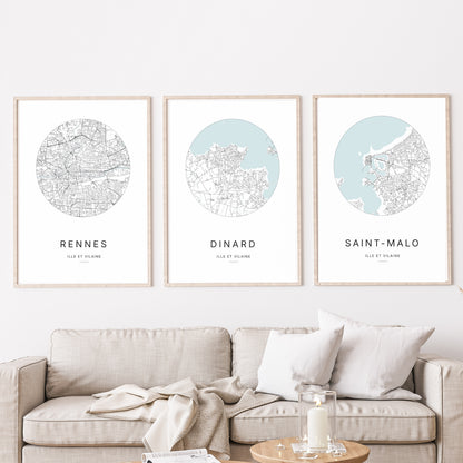 Composition murale de trois affiches minimalistes de villes (Dinard, Saint-Malo, Rennes) encadrées au-dessus d’un canapé dans un salon moderne
