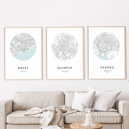 Composition murale de trois affiches minimalistes de villes (Quimper, Vannes, Brest) encadrées au-dessus d’un canapé dans un salon moderne