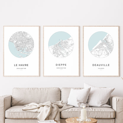Composition murale de trois affiches minimalistes de villes (Dieppe, Le Havre, Deauville) encadrées au-dessus d’un canapé dans un salon moderne.