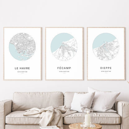 Composition murale de trois affiches minimalistes de villes (Fécamp, Le Havre, Dieppe) encadrées au-dessus d’un canapé dans un salon moderne.