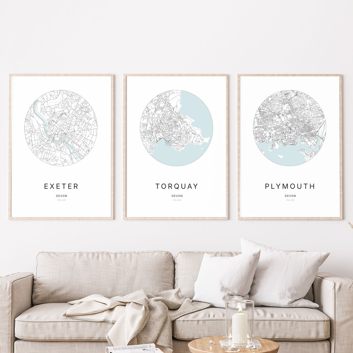 Trio of Exeter, Torquay and Plymouth city map prints in a living room.