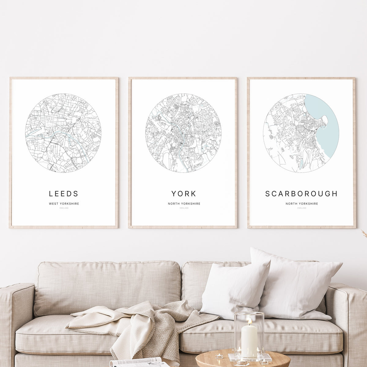 Trio of Leeds, York and Scarborough city map prints in a living room.