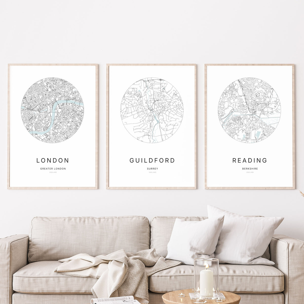 Trio of London, Guildford and Reading city map prints in a living room.