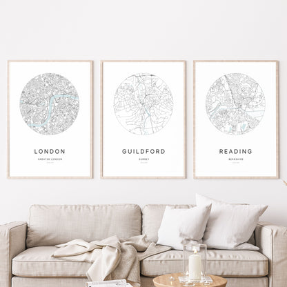 Trio of London, Guildford and Reading city map prints in a living room.