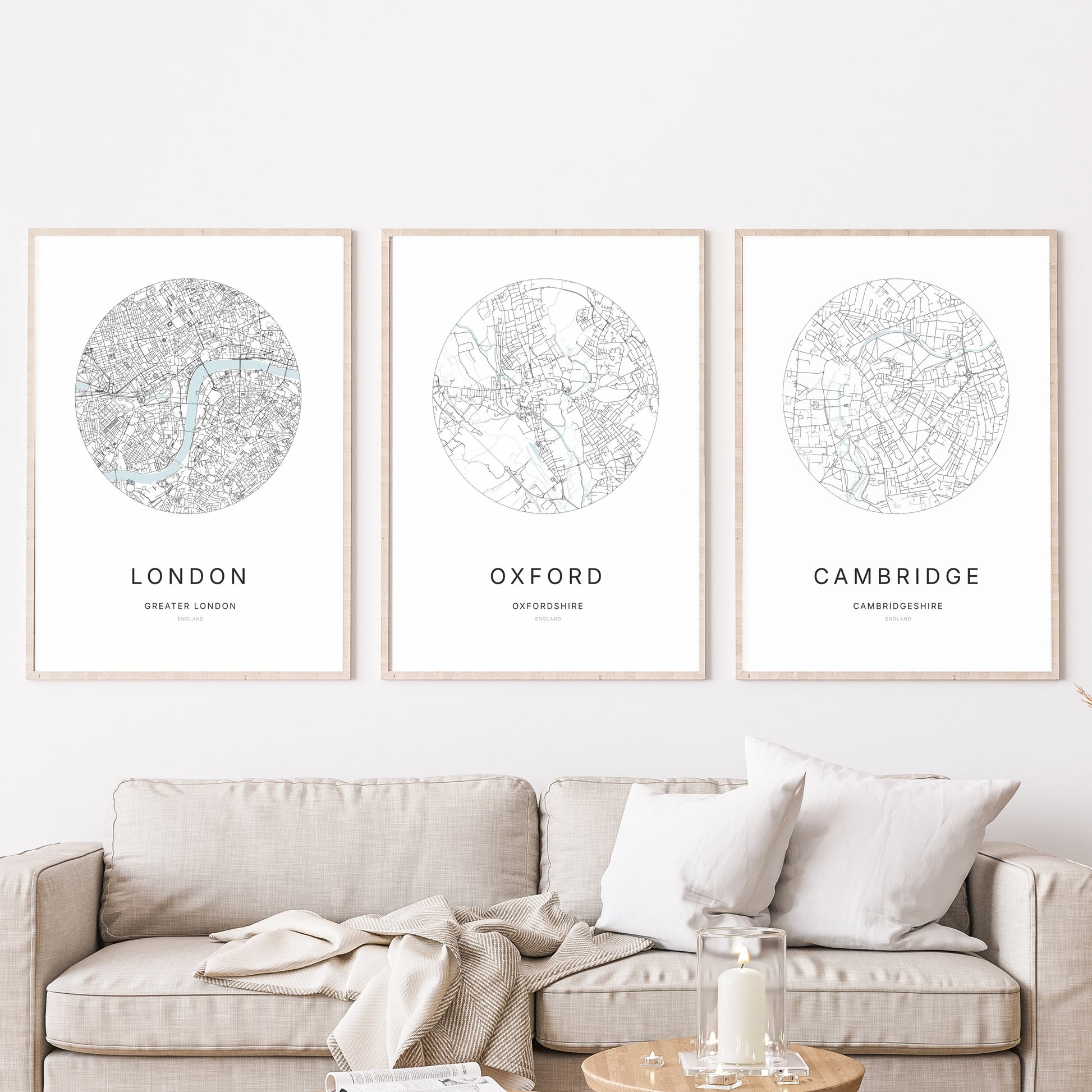 Trio of London, Oxford and Cambridge city map prints in a living room.