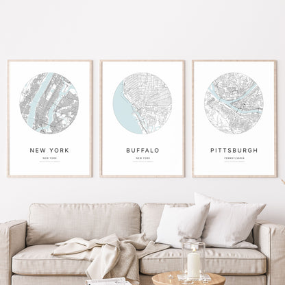 Trio of New York City, Buffalo and Pittsburgh city map posters in a living room.