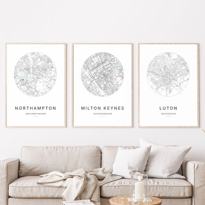 Trio of Northampton, Milton Keynes and Luton city map prints in a living room.