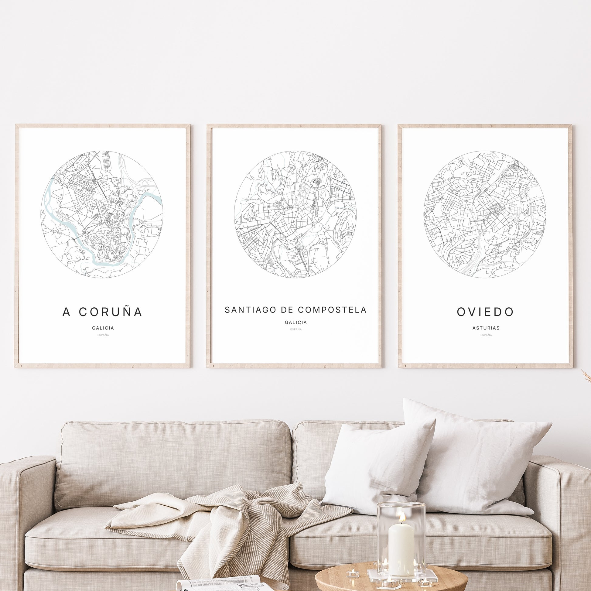 Trio d'affiches de Santiago de Compostela, A Coruña et Oviedo dans un salon.