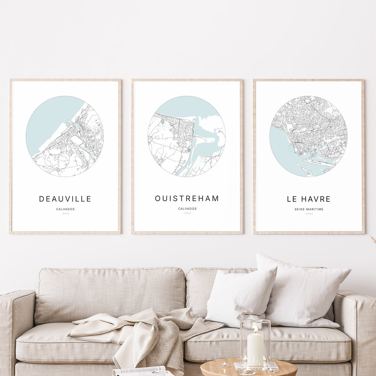 Trio d'affiches de Ouistreham, Deauville et Le Havre dans un salon.
