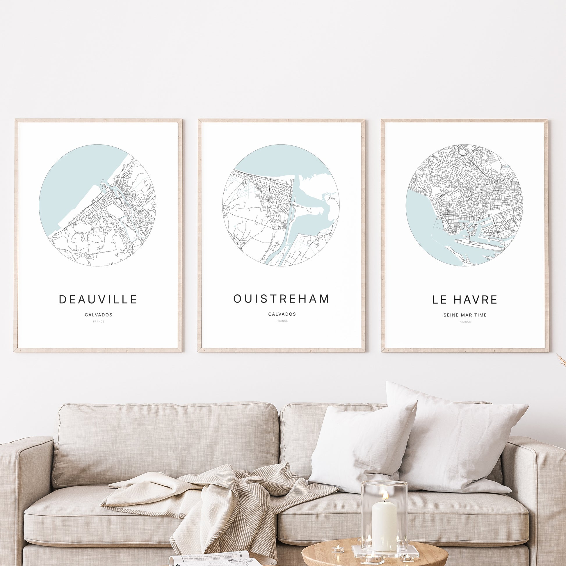 Trio d'affiches de Ouistreham, Deauville et Le Havre dans un salon.