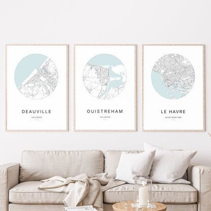 Trio d'affiches de Ouistreham, Deauville et Le Havre dans un salon.