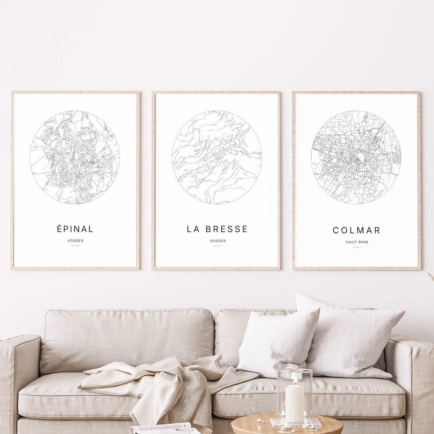 Trio d’affiches de La Bresse, Épinal et Colmar dans un salon.