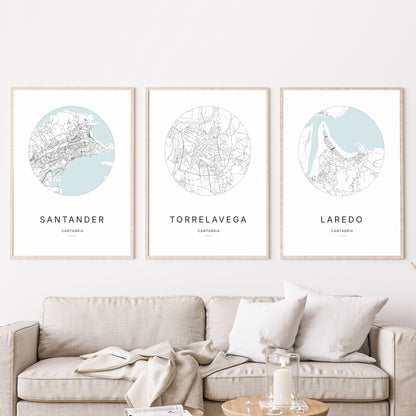 Trío de pósteres de Torrelavega, Santander y Laredo en un salón.