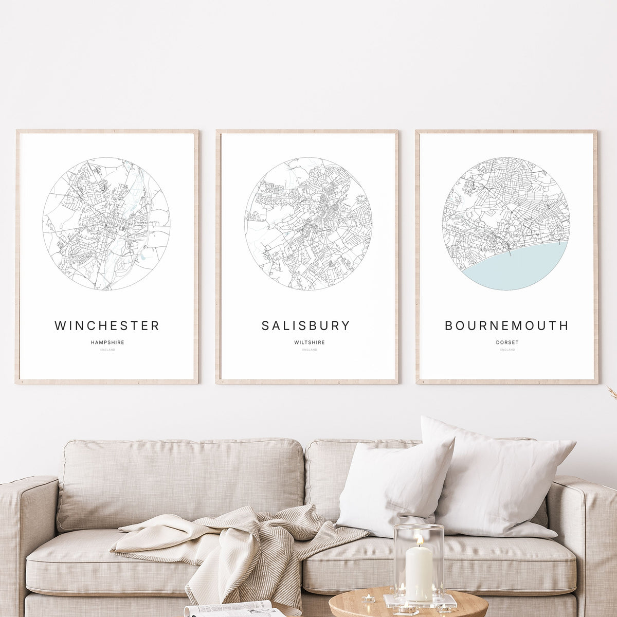 Trio of Winchester, Salisbury and Bournemouth city map prints in a living room.