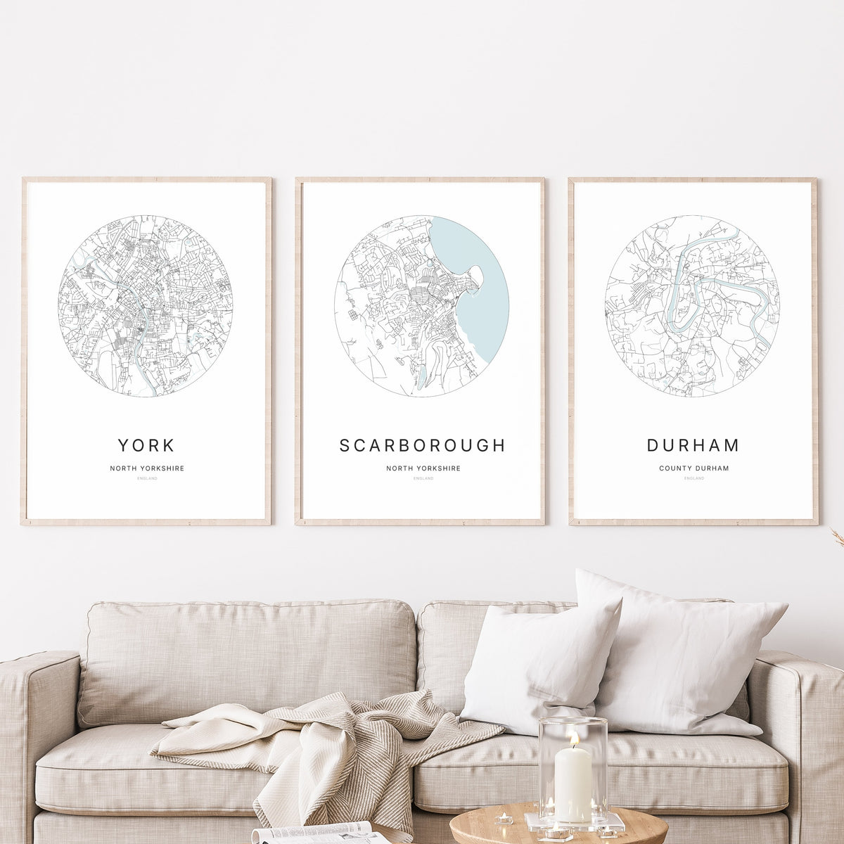 Trio of York, Scarborough and Durham city map prints in a living room.