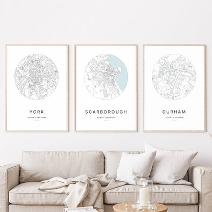 Trio of York, Scarborough and Durham city map prints in a living room.